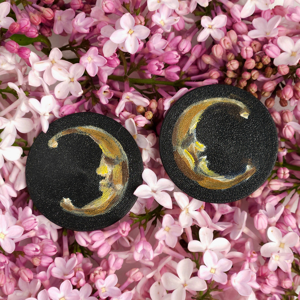 Black earrings with golden accents on pink flowers