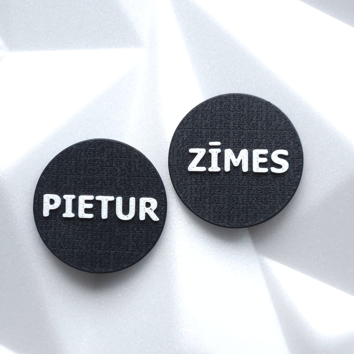 PIETUR ZĪMES teksta auskaru pāris, melni ar baltu uzrakstu