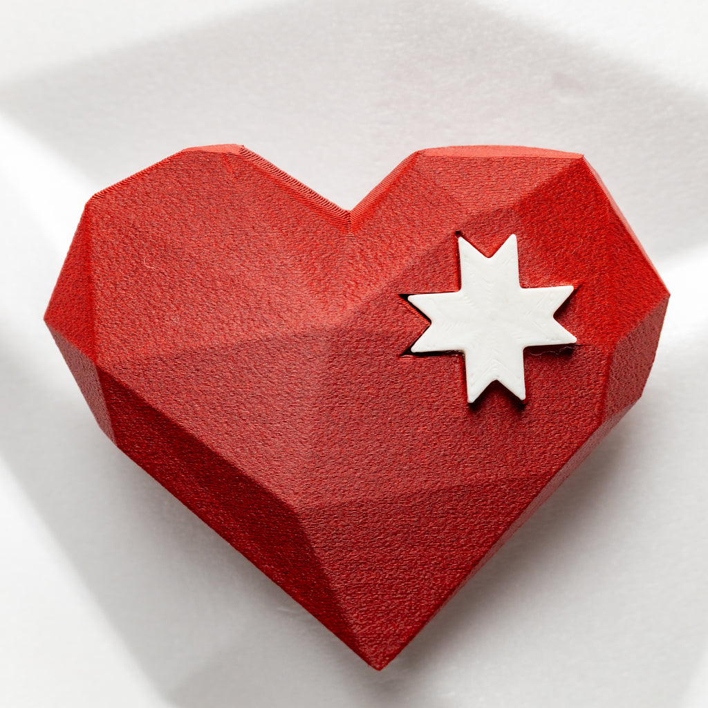 Red geometric heart-shaped object with a morning star on a white background