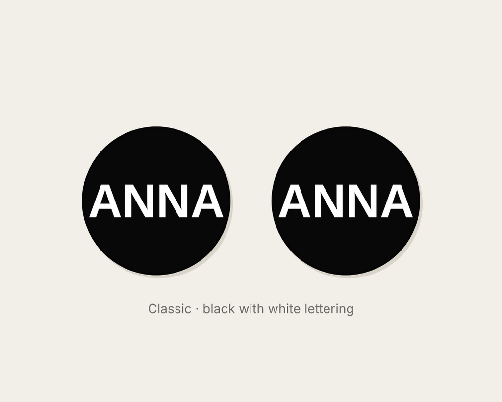 Pair of 42mm black custom text earrings reading ANNA in white Classic lettering