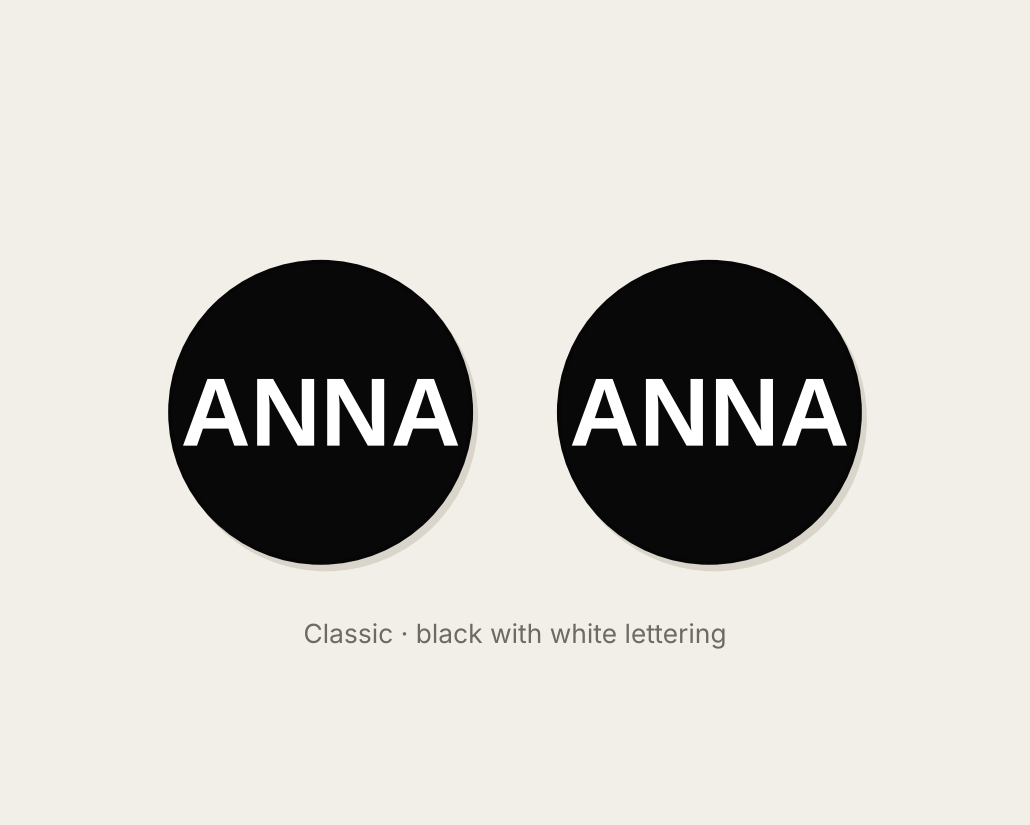 Pair of 42mm black custom text earrings reading ANNA in white Classic lettering