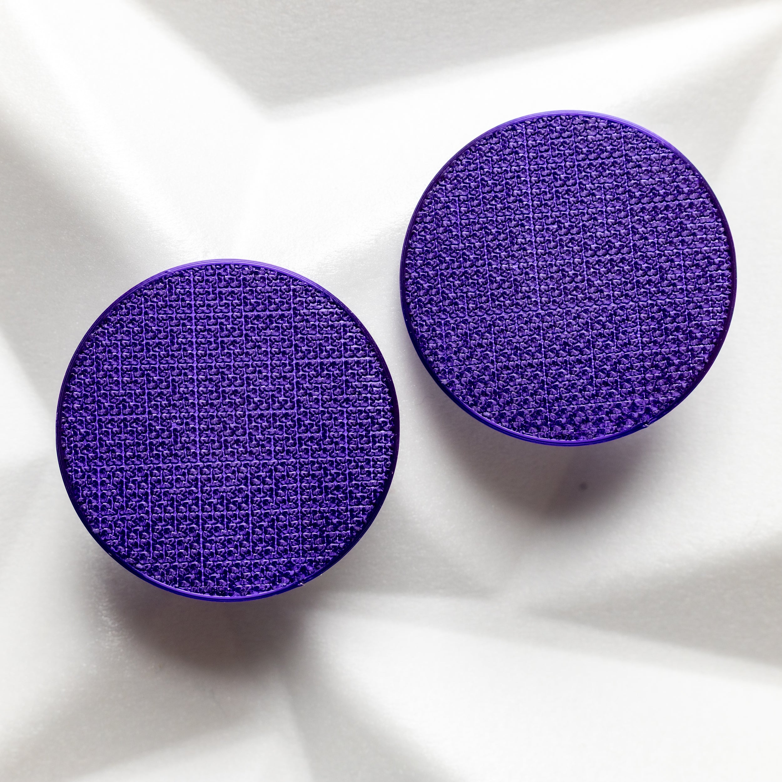 two purple clip on earrings with textured surface for non pierced ears